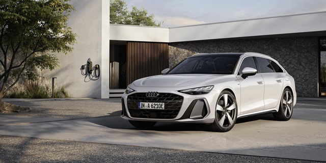 Weißer Audi A6 Avant parkt vor einem modernen Haus.