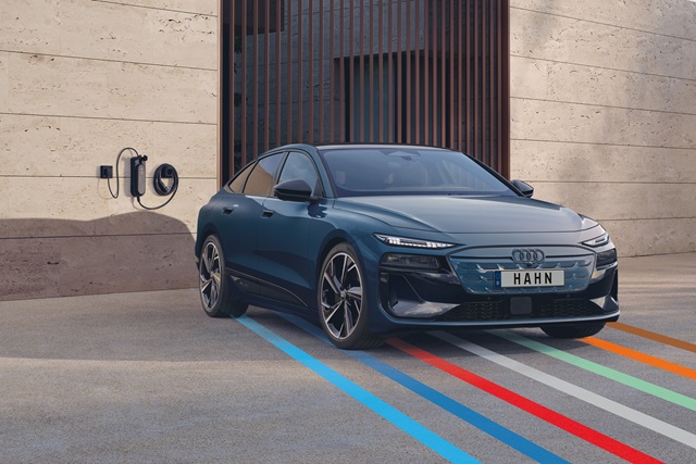 Blauer Audi A6 Sportback e-tron parkt vor einer Wallbox.