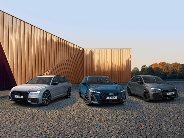 Drei Audi-Modelle nebeneinander auf einem Parkplatz vor modernem Gebäude geparkt