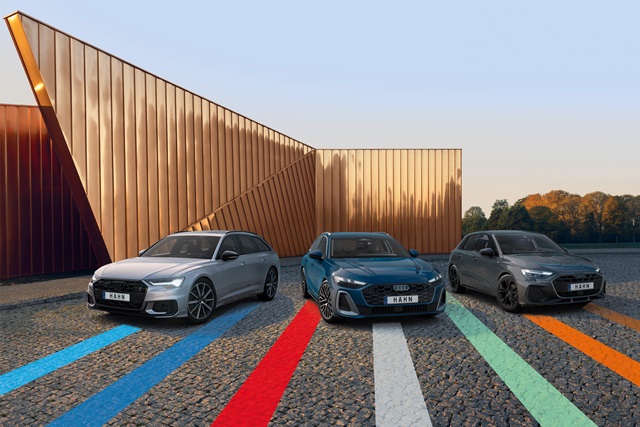 Drei Audi-Modelle nebeneinander auf einem Parkplatz vor modernem Gebäude geparkt