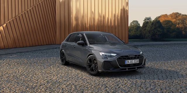 Grauer Audi A3 Sportback in Frontansicht vor modernem Gebäude 