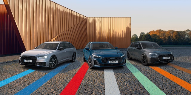 Drei Audi-Modelle nebeneinander auf einem Parkplatz vor modernem Gebäude geparkt