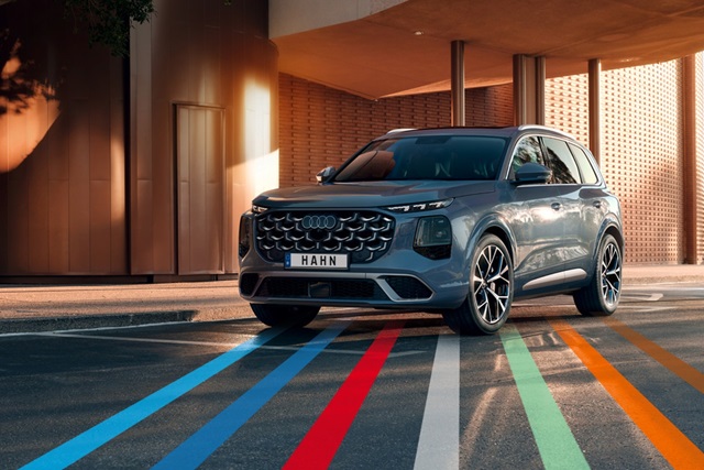 Audi Q7 SUV in Frontansicht vor modernem Gebäude mit farbigen Linien auf dem Boden