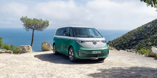 Der Volkswagen ID. Buzz parkend auf einem Parkplatz mit Meereskulisse im Hintergrund. 