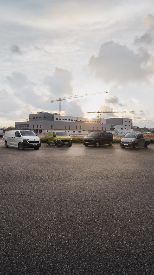 Vier Transporter Modelle parken vor einem Gebäude, das im Hintergrund sichtbar ist.
