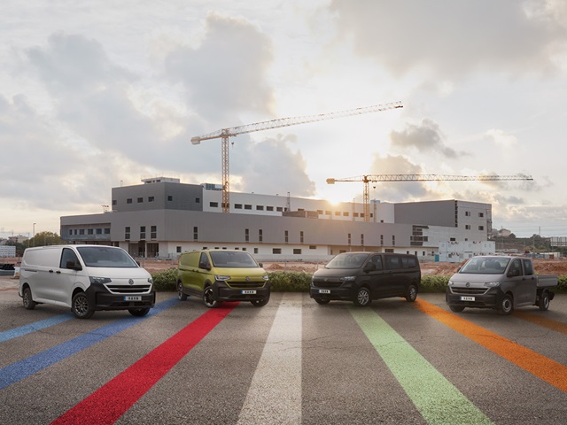 Vier Transporter Modelle parken vor einem Gebäude, das im Hintergrund sichtbar ist.