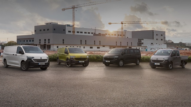 Vier Transporter Modelle parken vor einem Gebäude, das im Hintergrund sichtbar ist.