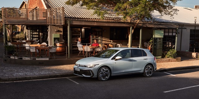 Seitenansicht eines weißen VW Golf vor einem Restaurant