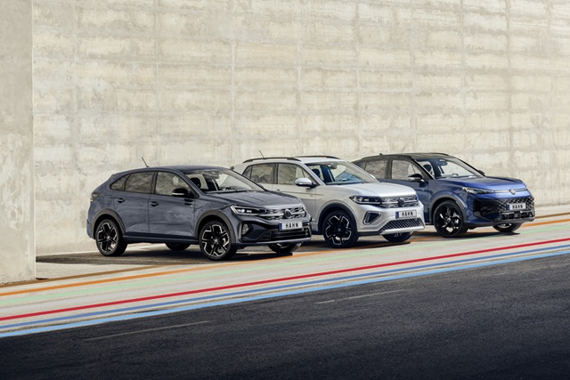 VW Taigo, T-Cross und T-Roc in unterschiedlichen Farben nebeneinander vor einer Betonwand auf einer Straße.