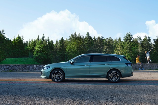 Ein Volkswagen Passat vor einer grünen Waldlandschaft.