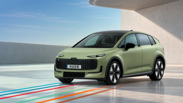 Hellgrüner Audi A2 e-tron mit schwarzem Dach und markantem Frontgrill in moderner Architekturkulisse