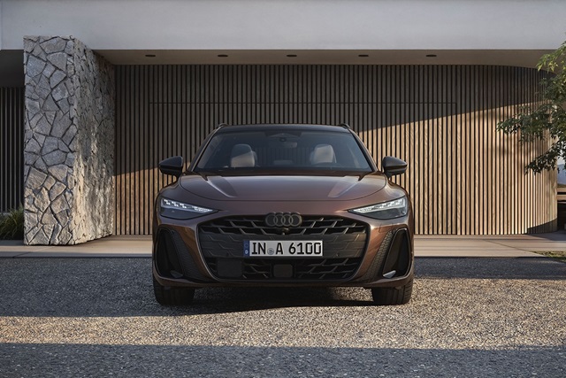 Der Audi A6 Avant parkend vor einem modernen Gebäude in Frontansicht.