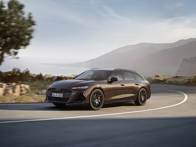 Der Audi A6 Avant in Fahrt auf einer Küstenstraße in Seitenansicht.