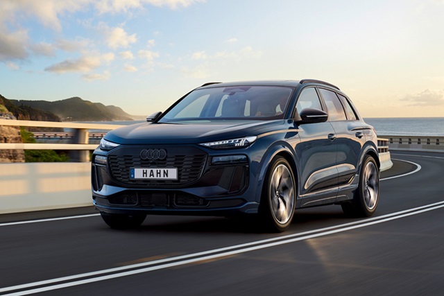 Audi Q6 SUV e-tron auf einer Küstenstraße, elegante SUV-Linie und modernes Design bei Sonnenuntergang.