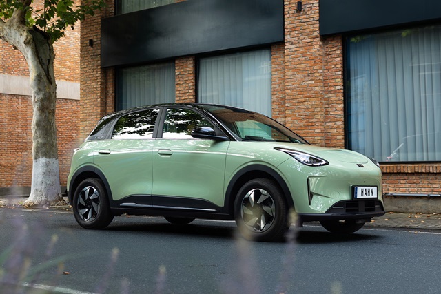 Geely E2 in der Seitenansicht, vor einem roten Backsteingebäude steht auf einer Straße