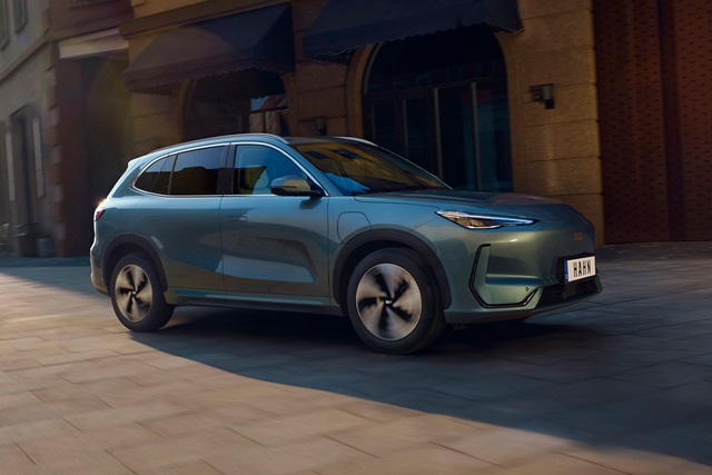 Geely Starray EM-i in dunkelgrüner Seitenansicht auf gepflasterter Straße vor historischen Gebäuden