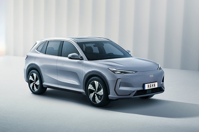 Silberner Geely Starray EM-i SUV in Seitenansicht vor hellgrauer Wand mit Nummernschild 'HAHN'