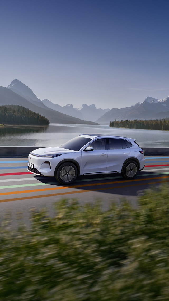 Weiße Seitenansicht des Geely Starray EM-i vor einem See mit Bergen im Hintergrund