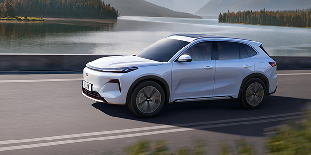 Geely Starry SUV fährt auf einer Straße entlang eines Sees mit bewaldeten Hügeln im Hintergrund
