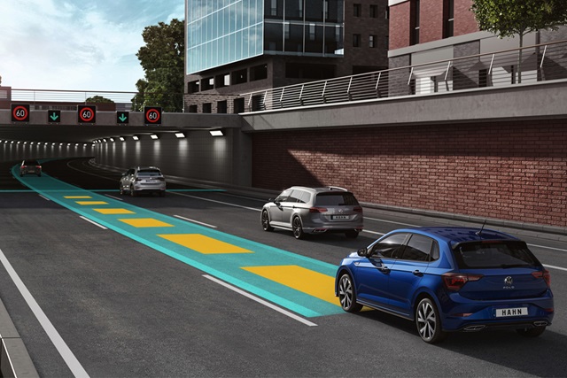 Drei VW Polo fahren hintereinander auf einer Straße mit markierten Fahrspuren und Geschwindigkeitsanzeige 60 km/h über einem Tunnel.