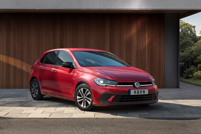 Roter VW Polo ENERGY in Frontansicht vor einer Holzfassade geparkt mit dem Kennzeichen 'HAHN'