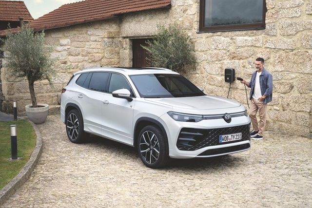 Der Volkswagen Tayron Hybrid in Front-Seitenansicht an einer Ladestation