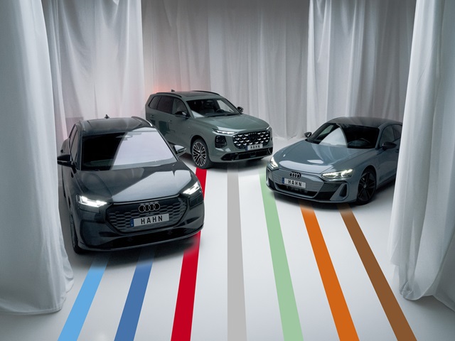 Drei Audi Modelle in einem weißen Raum mit weißen Vorhängen.