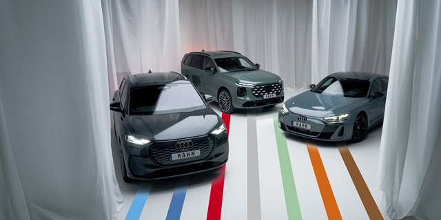 Drei Audi Modelle in einem weißen Raum mit weißen Vorhängen.
