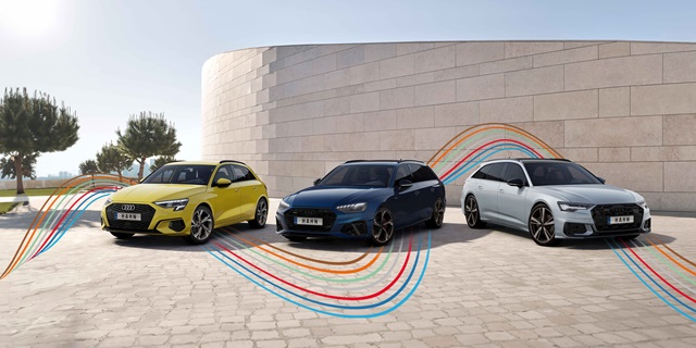 Audi Gebrauchtwagen :plus Wochen – Drei sportliche Audi-Fahrzeuge mit den bunten, dynamischen Linien des Hahn Codes vor einer Mauer.