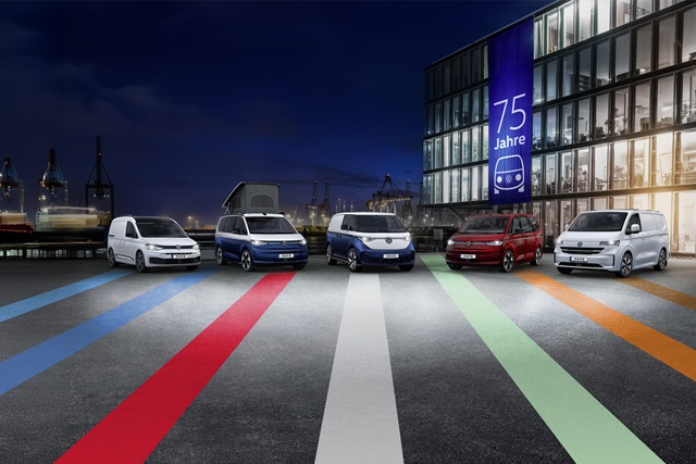 75 Jahre Bulli – Die Modelle VW Multivan, ID. Buzz, Transporter, California und Caddy   nebeneinander aufgereiht vor einem Gebäude