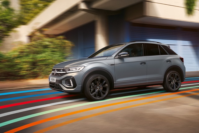 Grauer Volkswagen T-Roc SUV in Bewegung auf den bunten Streifen des Hahn Codes auf der Straße