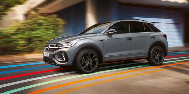 Grauer Volkswagen T-Roc SUV in Bewegung auf den bunten Streifen des Hahn Codes auf der Straße
